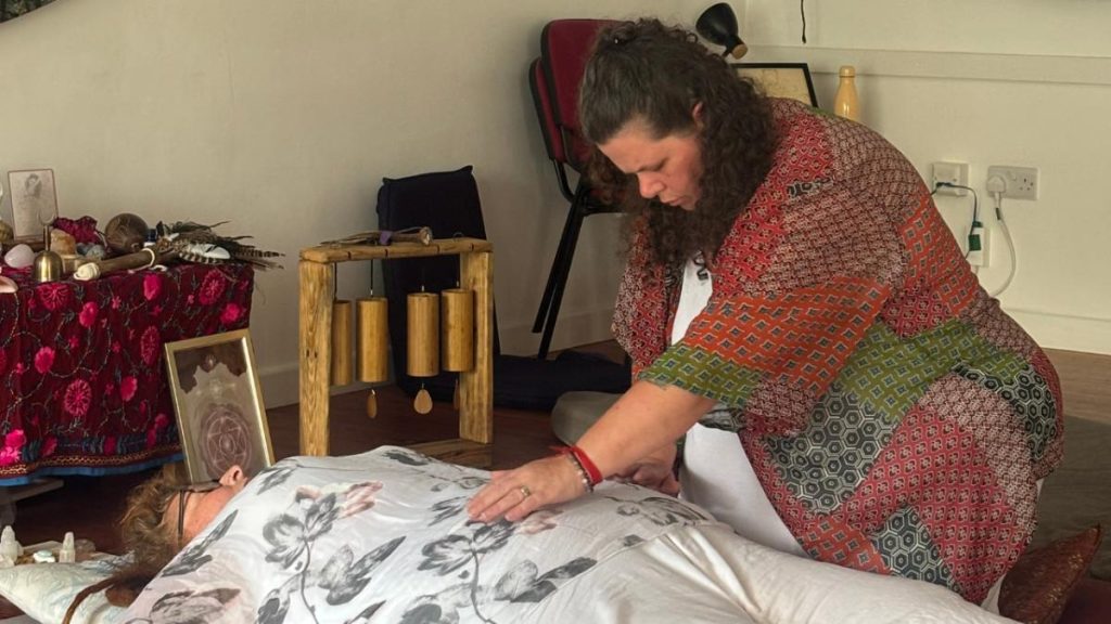 An experienced practitioner offers a private womb healing session as part of advanced womb training, facilitating energetic balance and release.